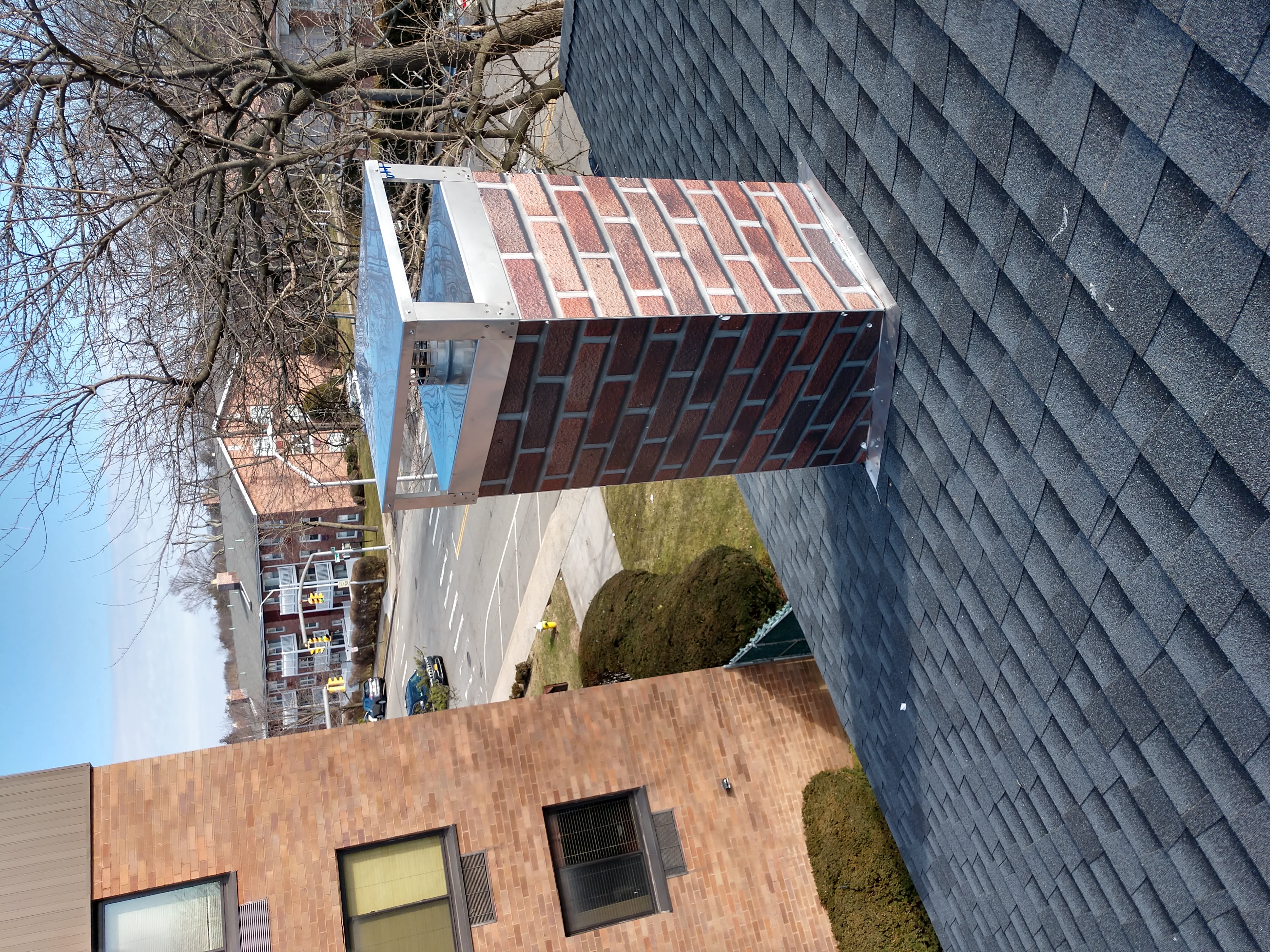 A CHIMNEY CHASE COVER PROTECTING THE CHIMNEY FROM RAIN AND SNOW IN FARMINGDALE
