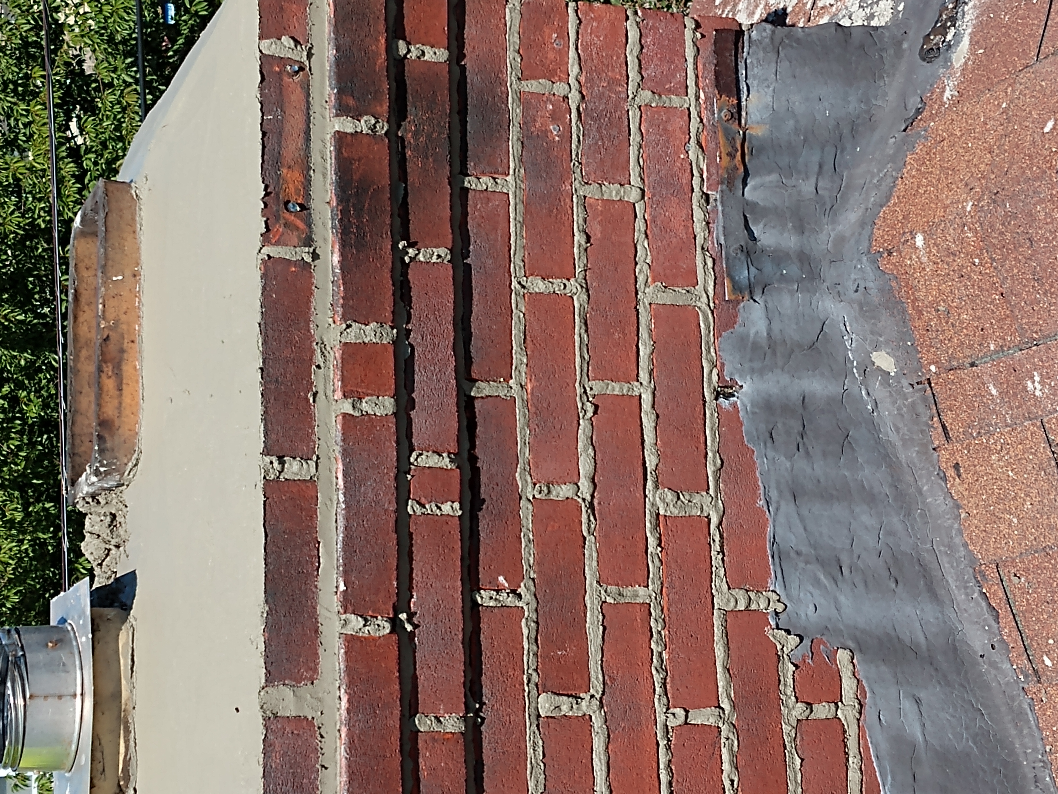 A NEWLY REPAIRED CHIMNEY CROWN WITH SEALANT IN FARMINGDALE