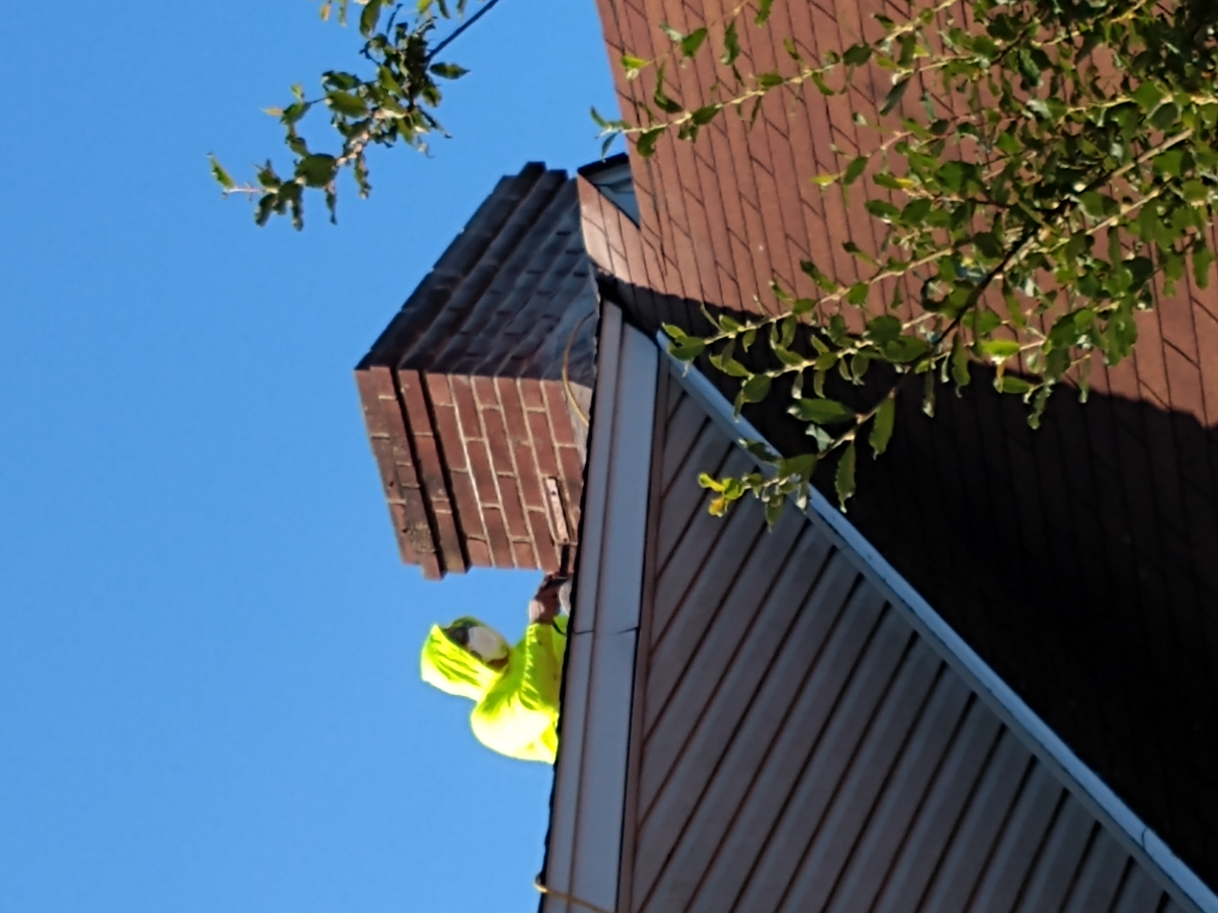 A CLOSE-UP OF A TECHNICIAN APPLYING FRESH MORTAR TO A CHIMNEY IN FARMINGDALE