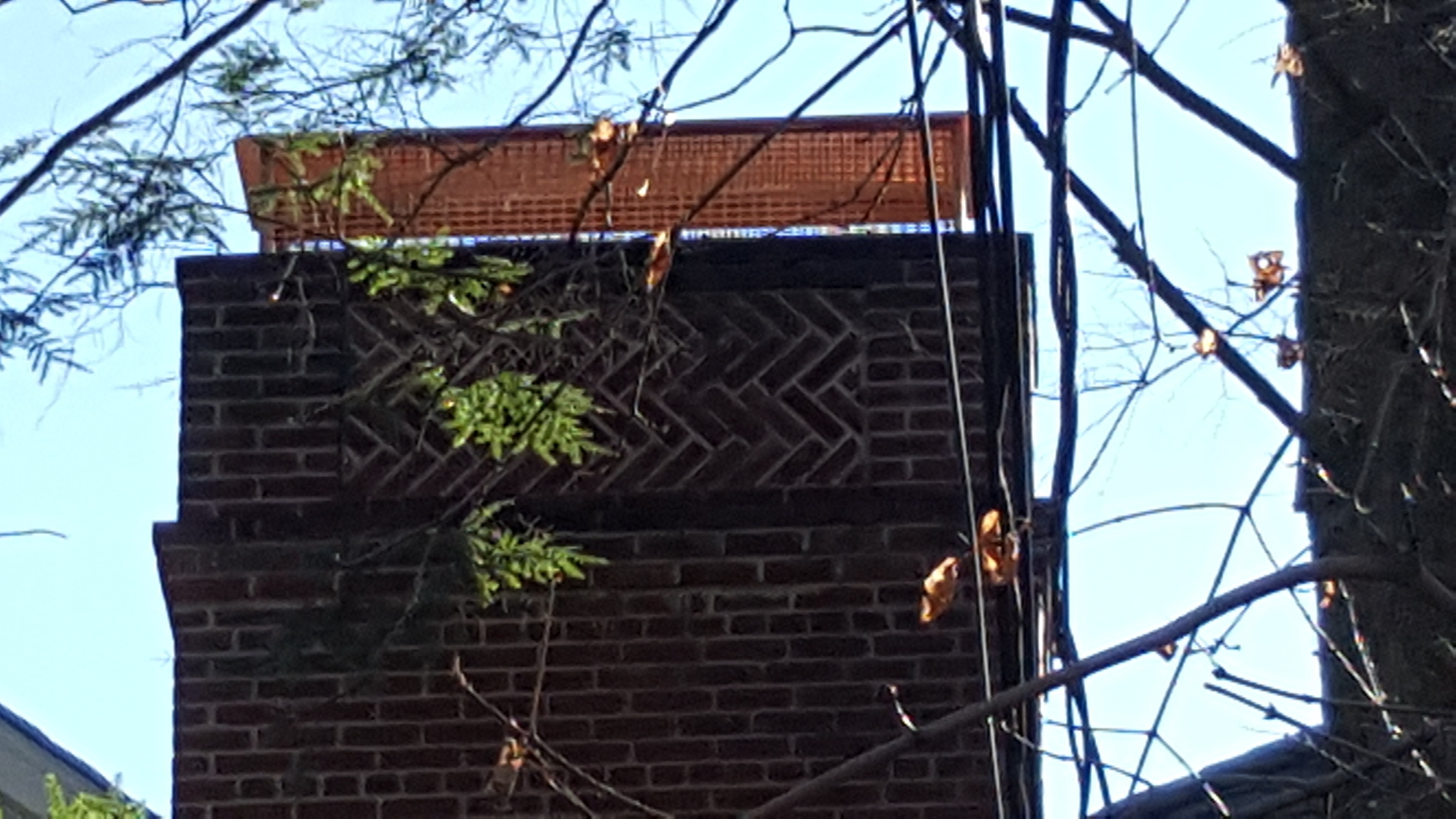 A WATERPROOFED BRICK CHIMNEY WITH WATER BEADED ON THE SURFACE, SHOWING THE PROTECTIVE LAYER IN FARMINGDALE